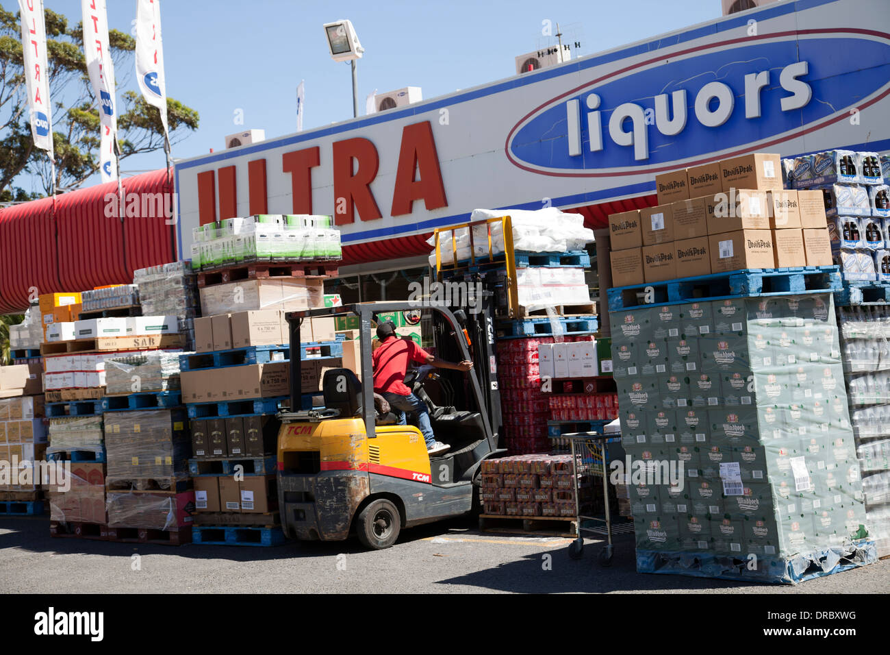 Employee Unpacking Containers of Beverages at Liqor Store in Cape Town