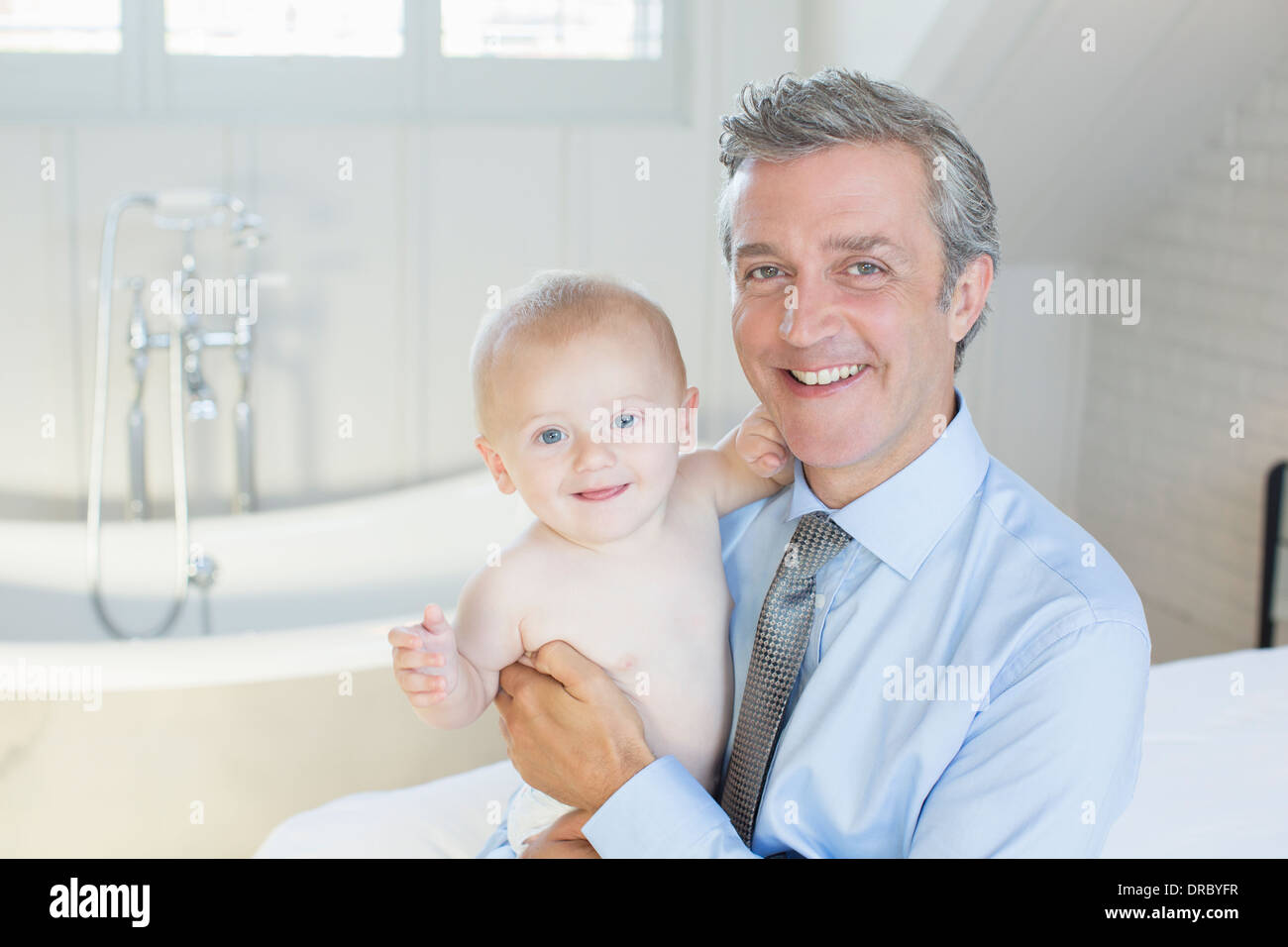Father holding baby in bathroom Stock Photo