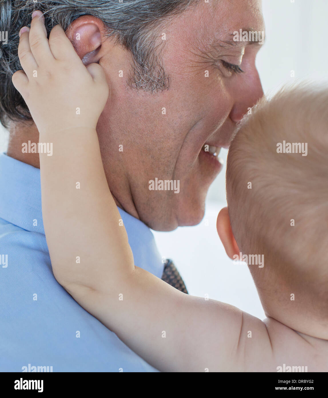 Close up of baby grabbing father's ear Stock Photo