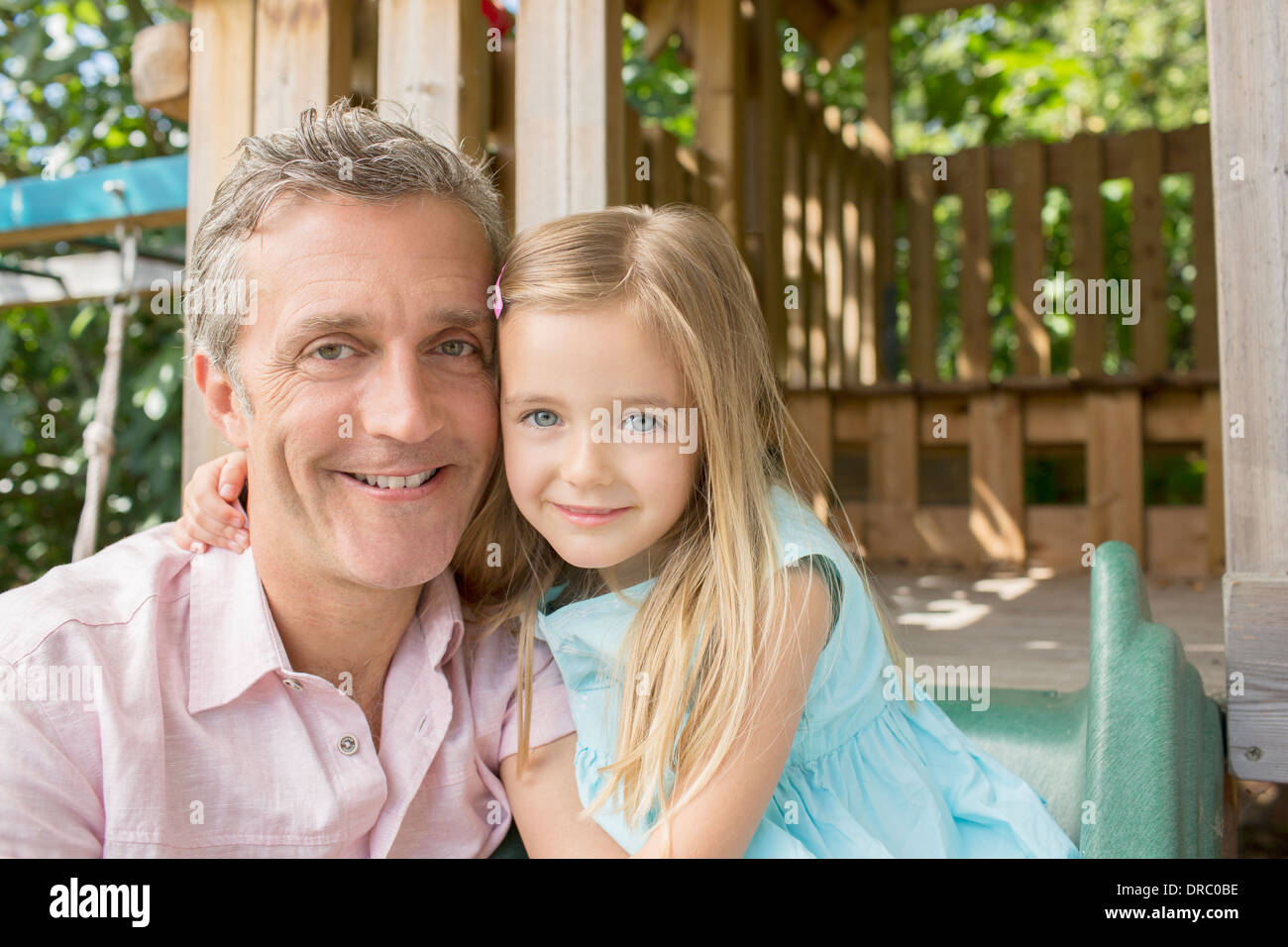 Father and daughter smiling on playset Stock Photo