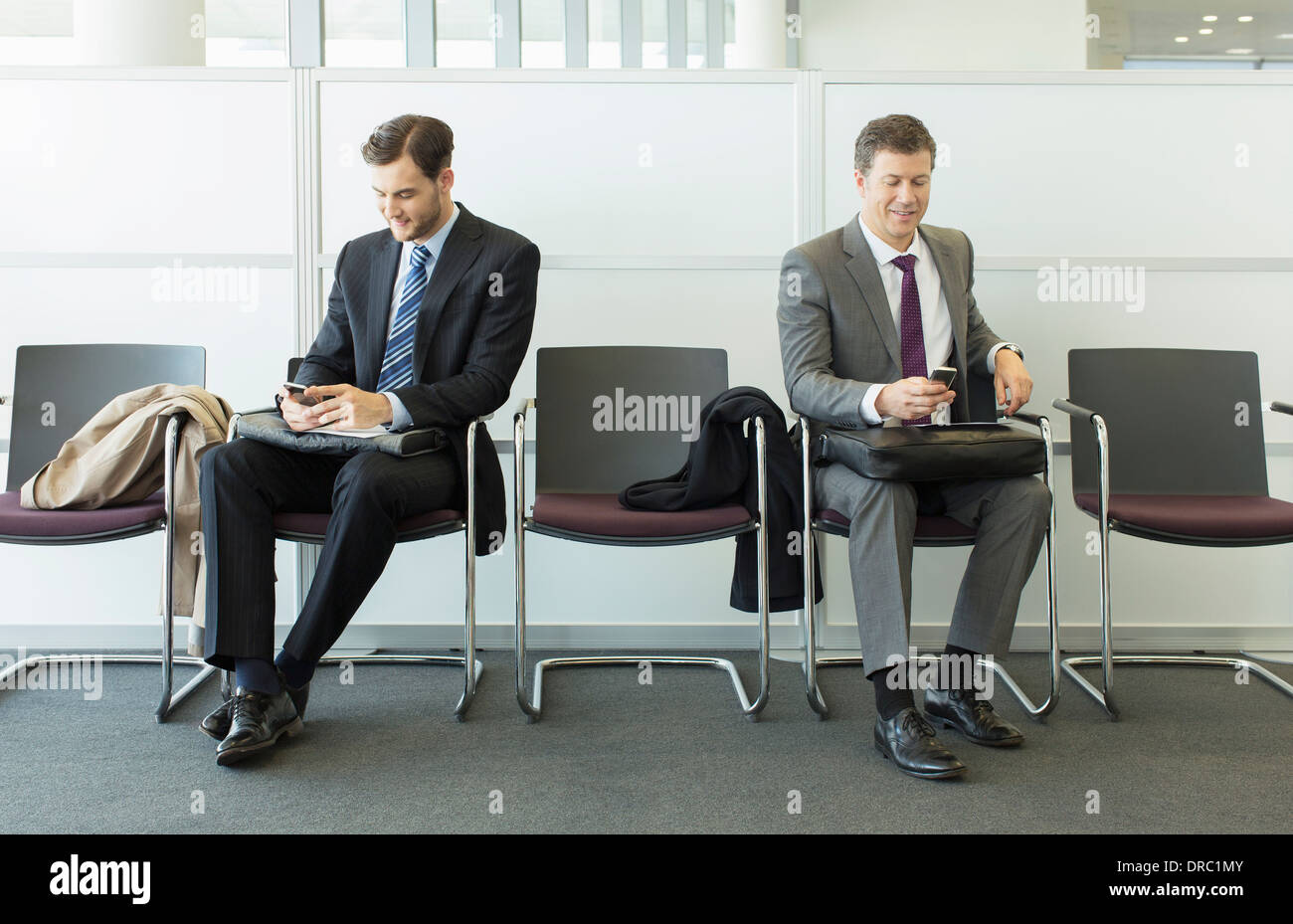 Businessmen sitting in waiting area Stock Photo