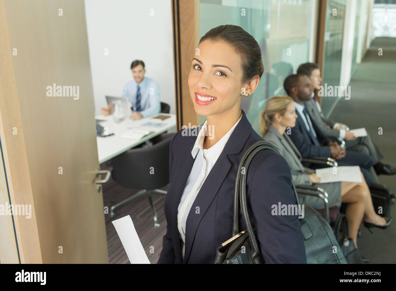 Businesswoman smiling in office doorway Stock Photo