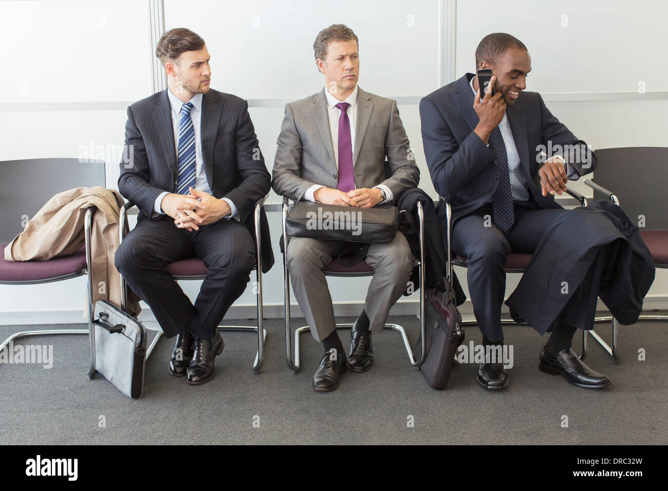 Businessmen sitting in waiting area Stock Photo