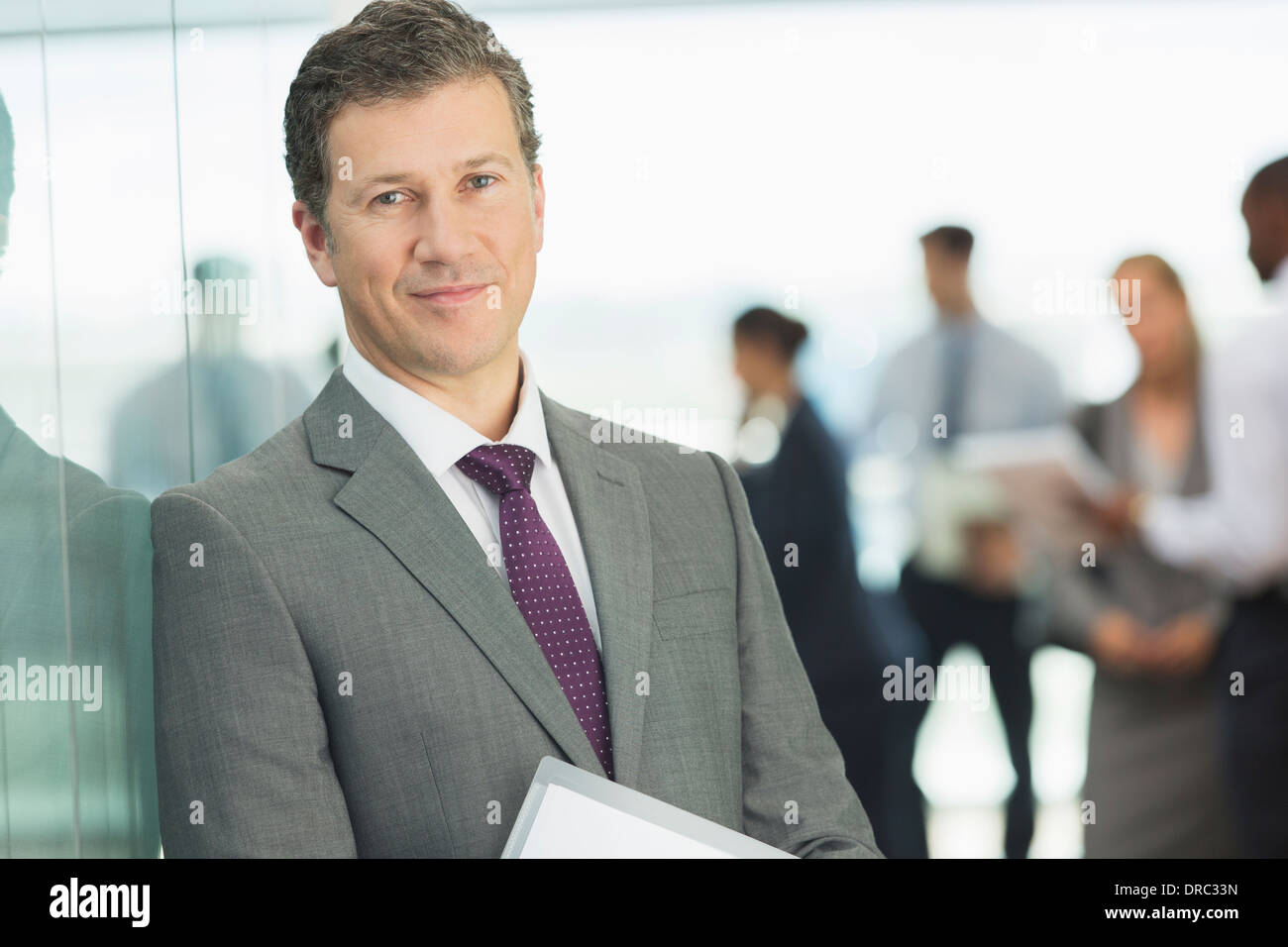 Businessman smiling in office Stock Photo