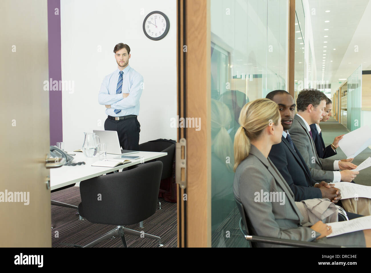 Businessman standing in office and business people in corridor Stock Photo