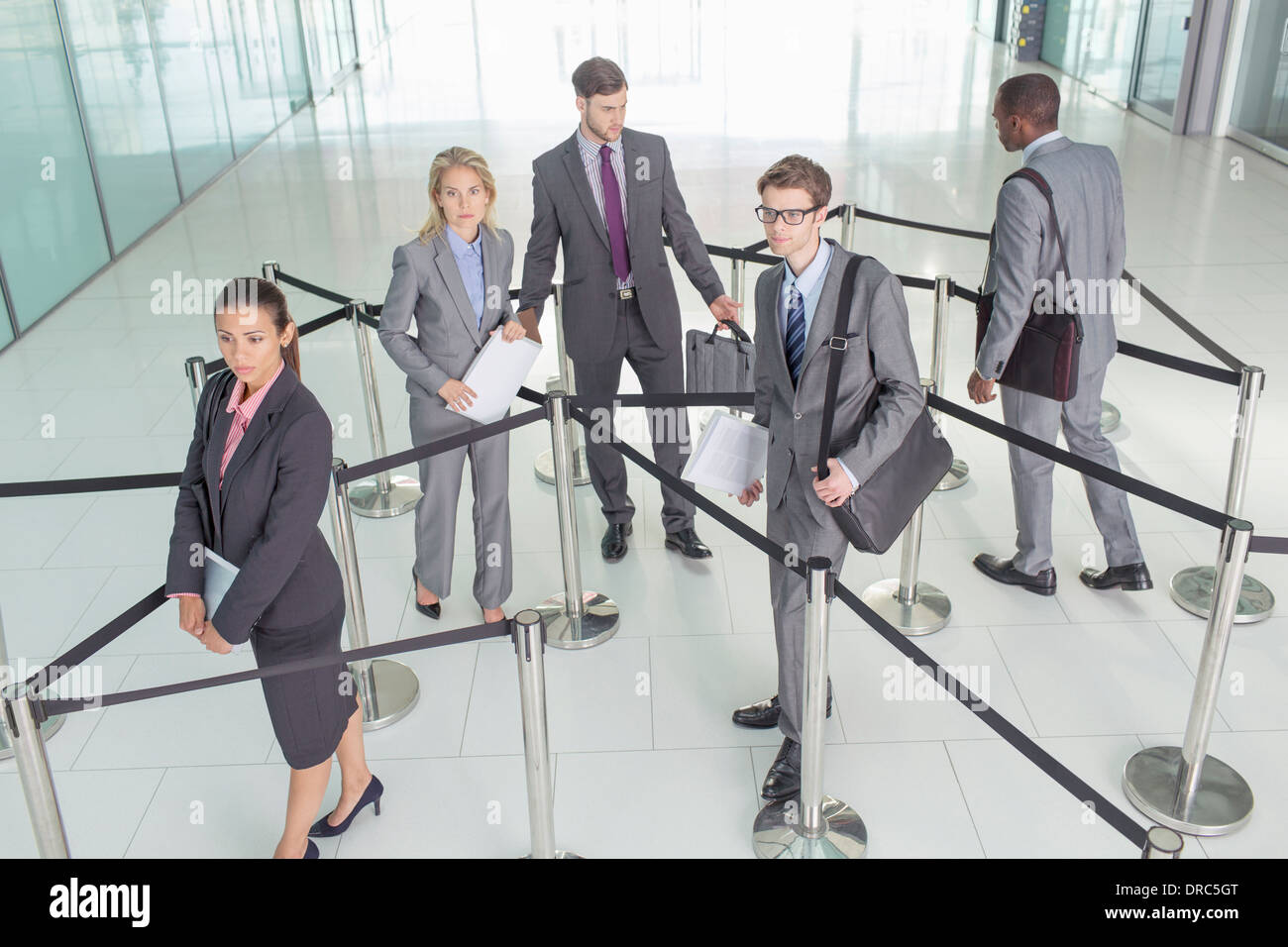Business people standing in ropedoff area Stock Photo Alamy