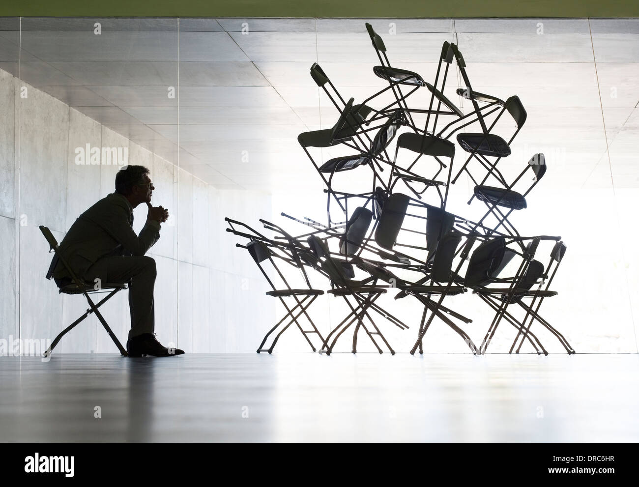 Businessman viewing office chair installation art Stock Photo