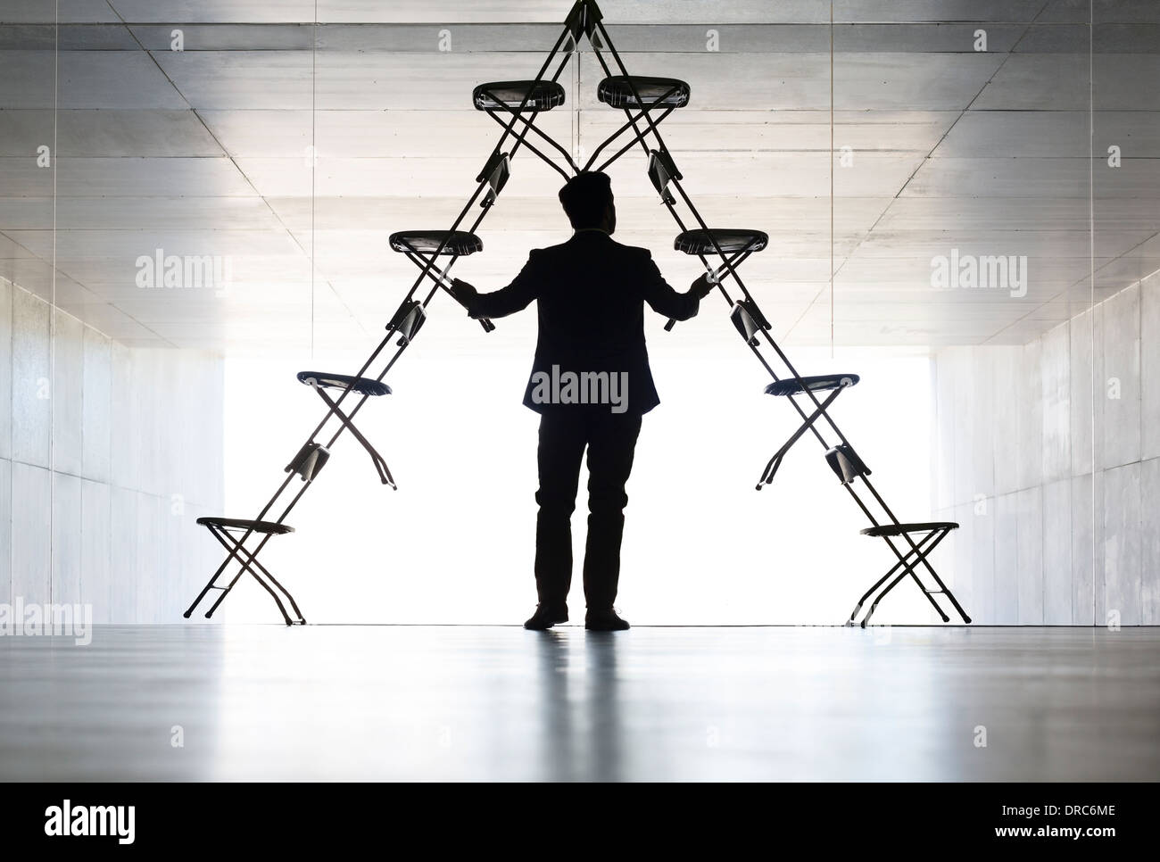 Businessman arranging office chair installation art Stock Photo