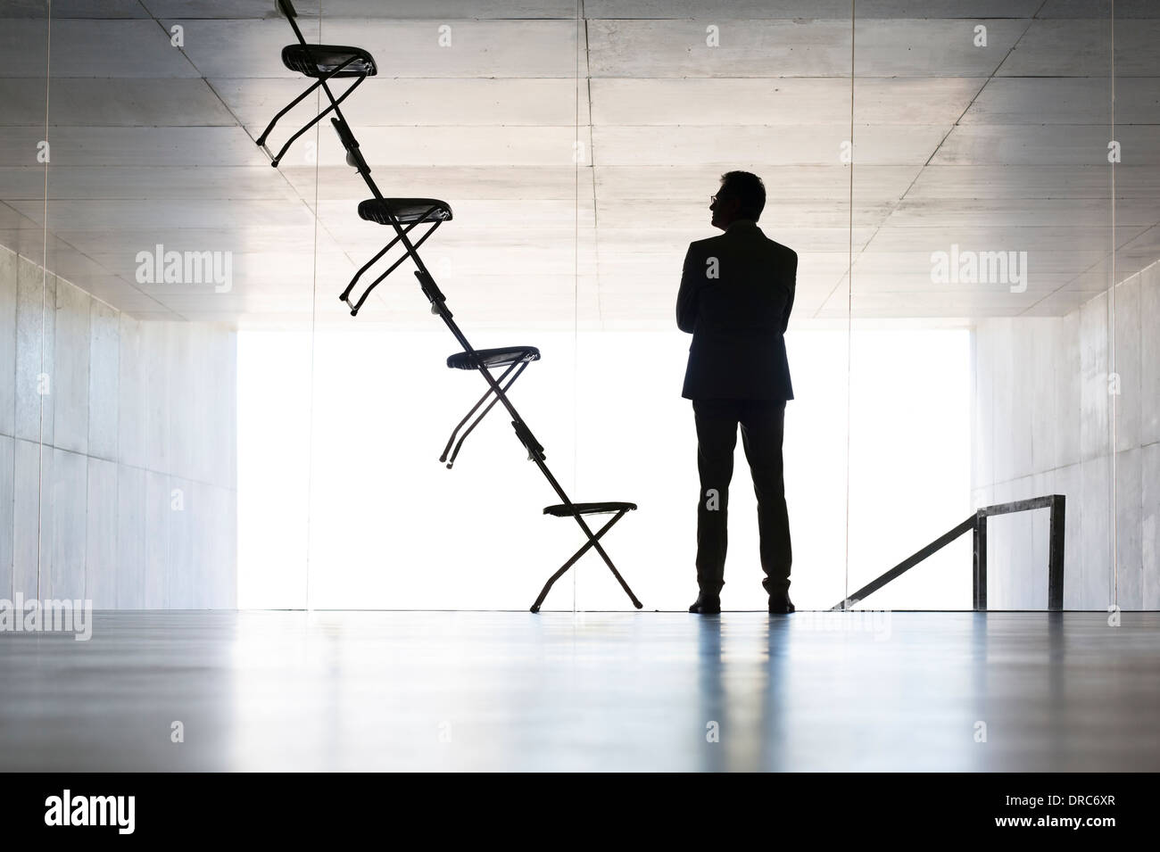 Businessman examining office chair installation art Stock Photo