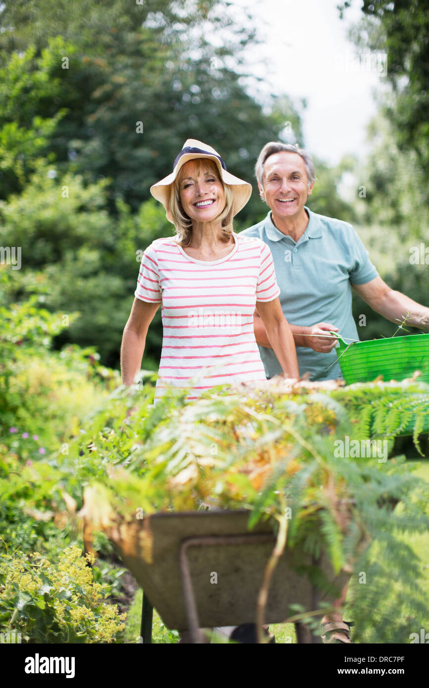 Senior couple with wheelbarrow and bucket in garden Stock Photo