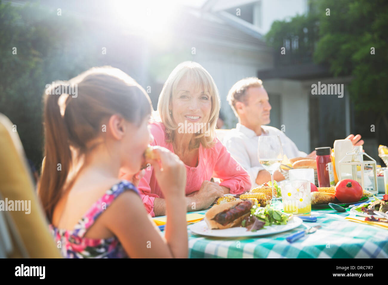 Family eating lunch at patio table Stock Photo