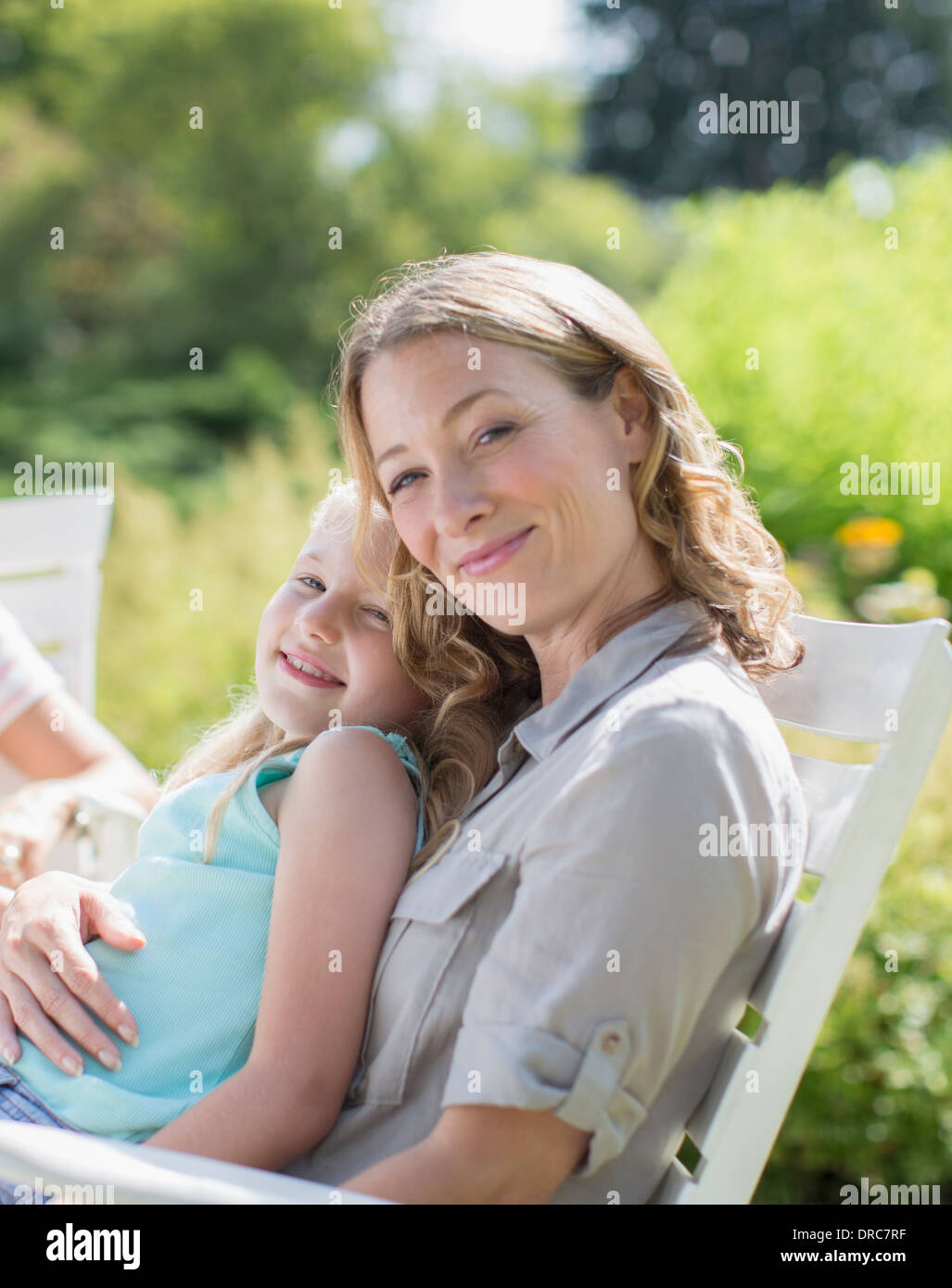 Mother and daughter relaxing in backyard Stock Photo