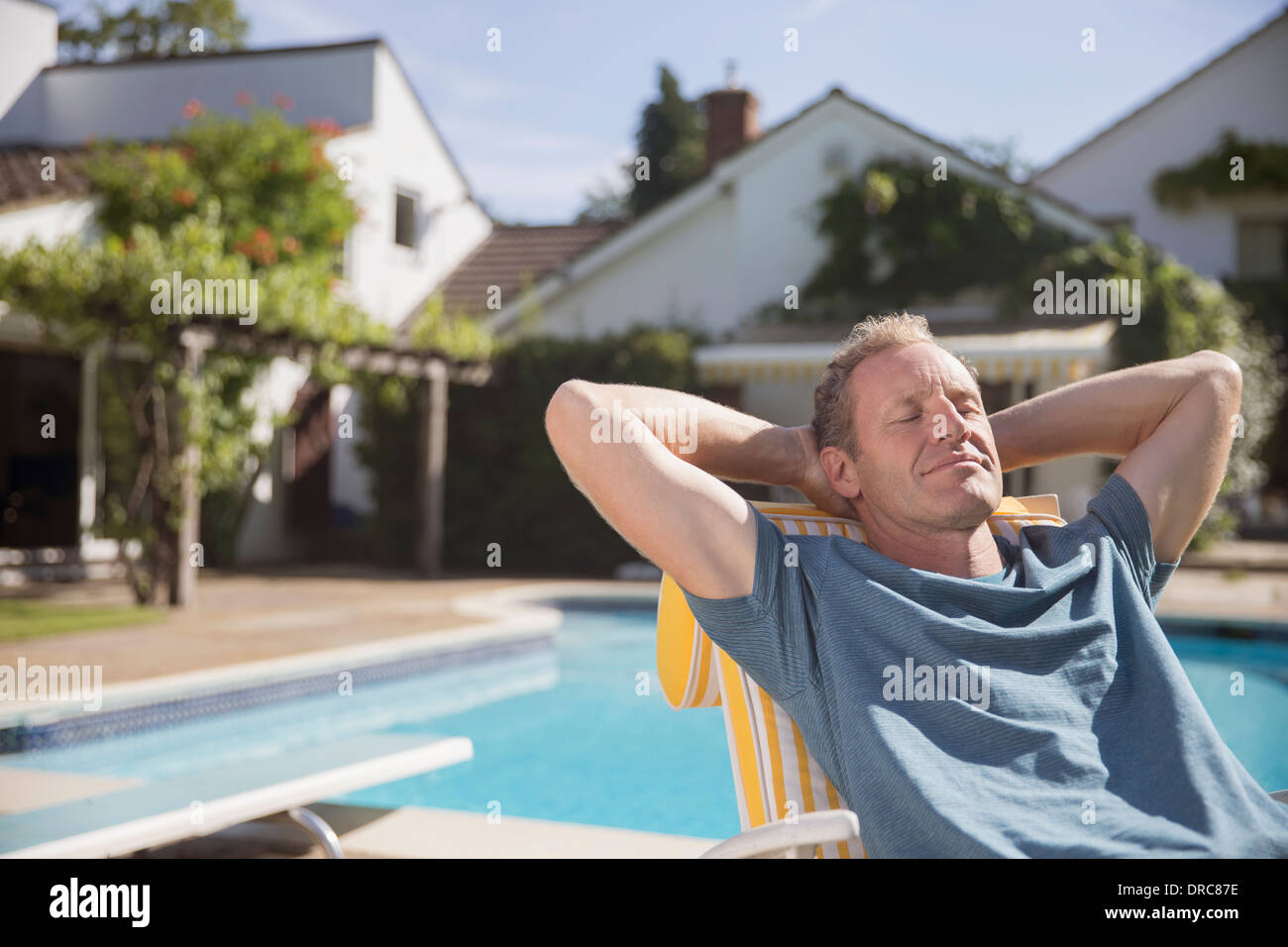 Man relaxing at poolside Stock Photo