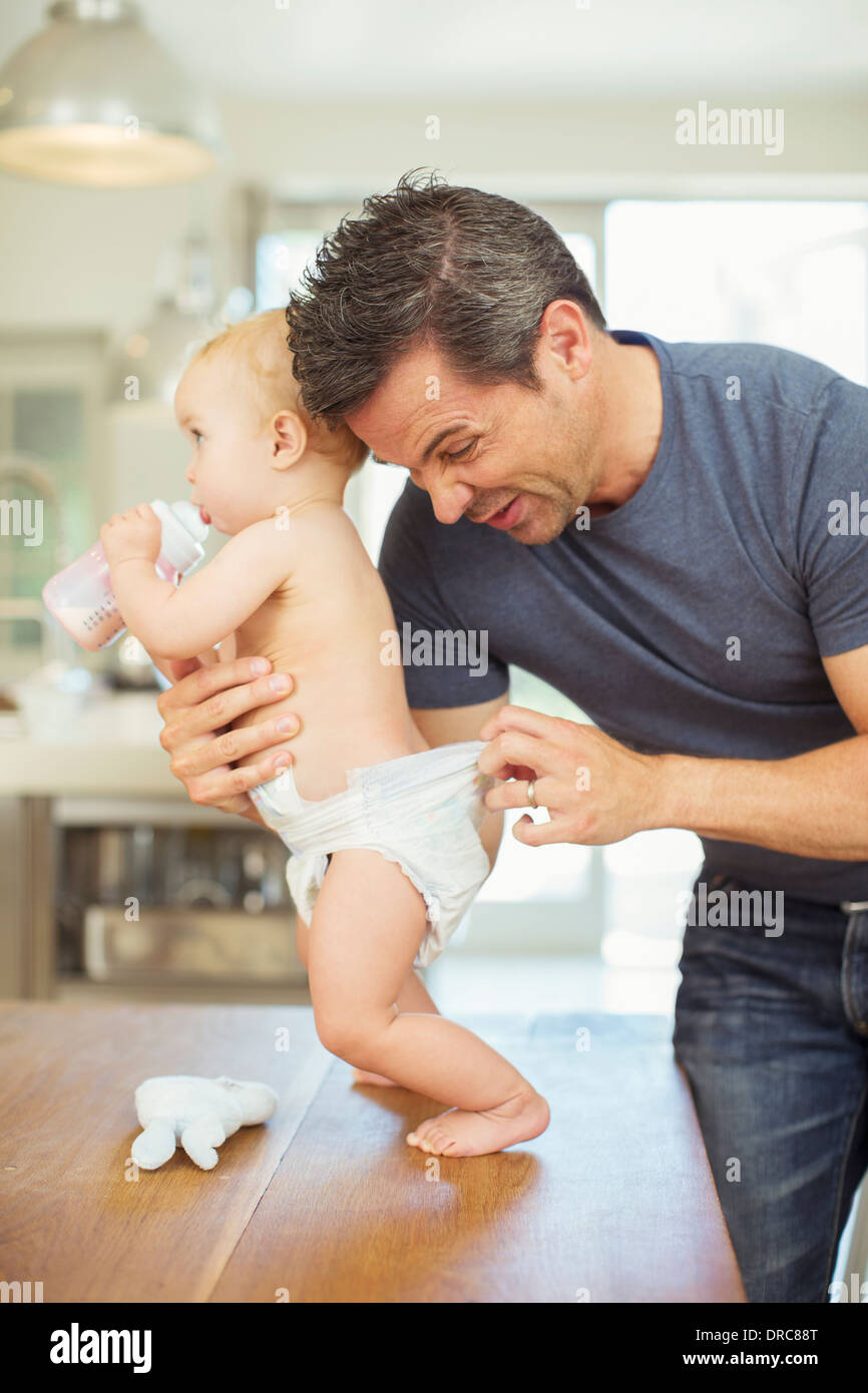 Father checking baby s diaper Stock Photo Alamy