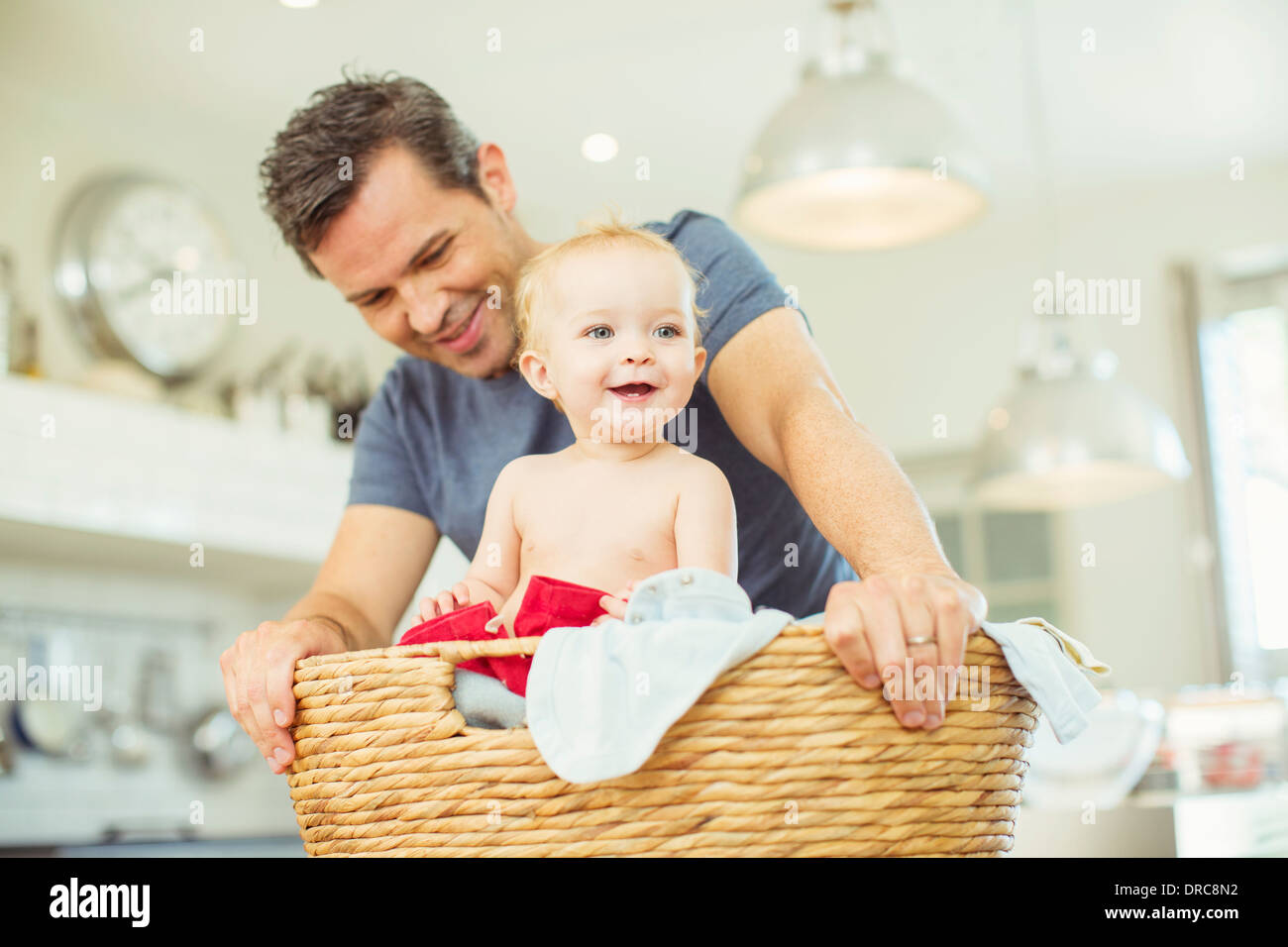 Father carrying baby in laundry basket Stock Photo Alamy