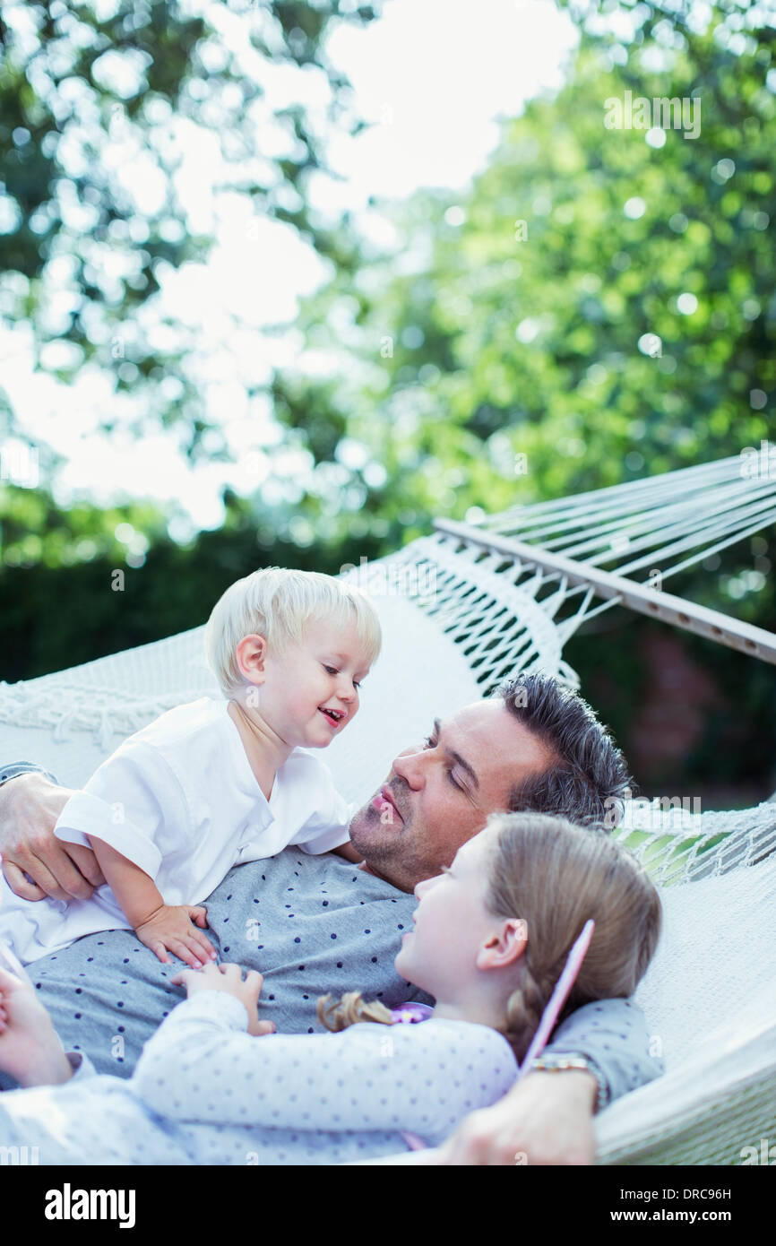 Father and children relaxing in hammock Stock Photo