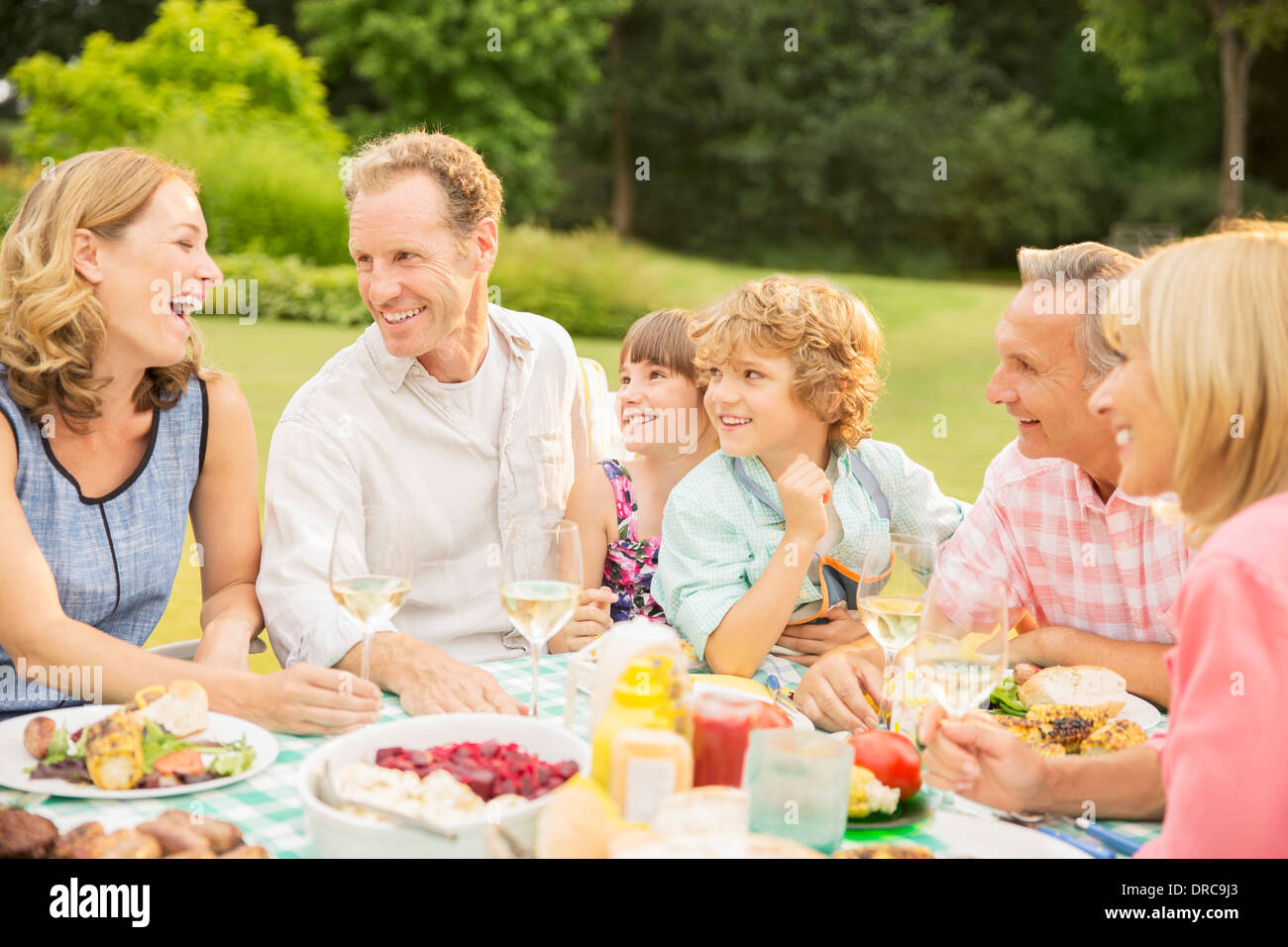 Multi-generation family enjoying lunch in backyard Stock Photo