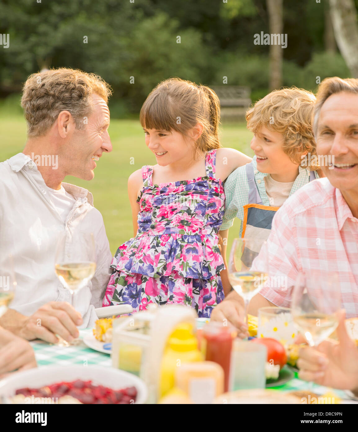 Family eating at table in backyard Stock Photo