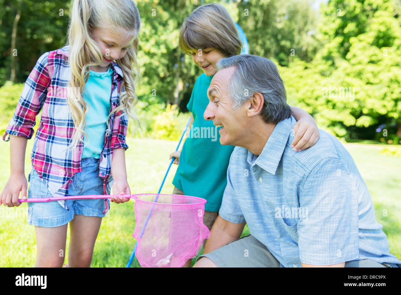Man and grandchildren playing outdoors Stock Photo