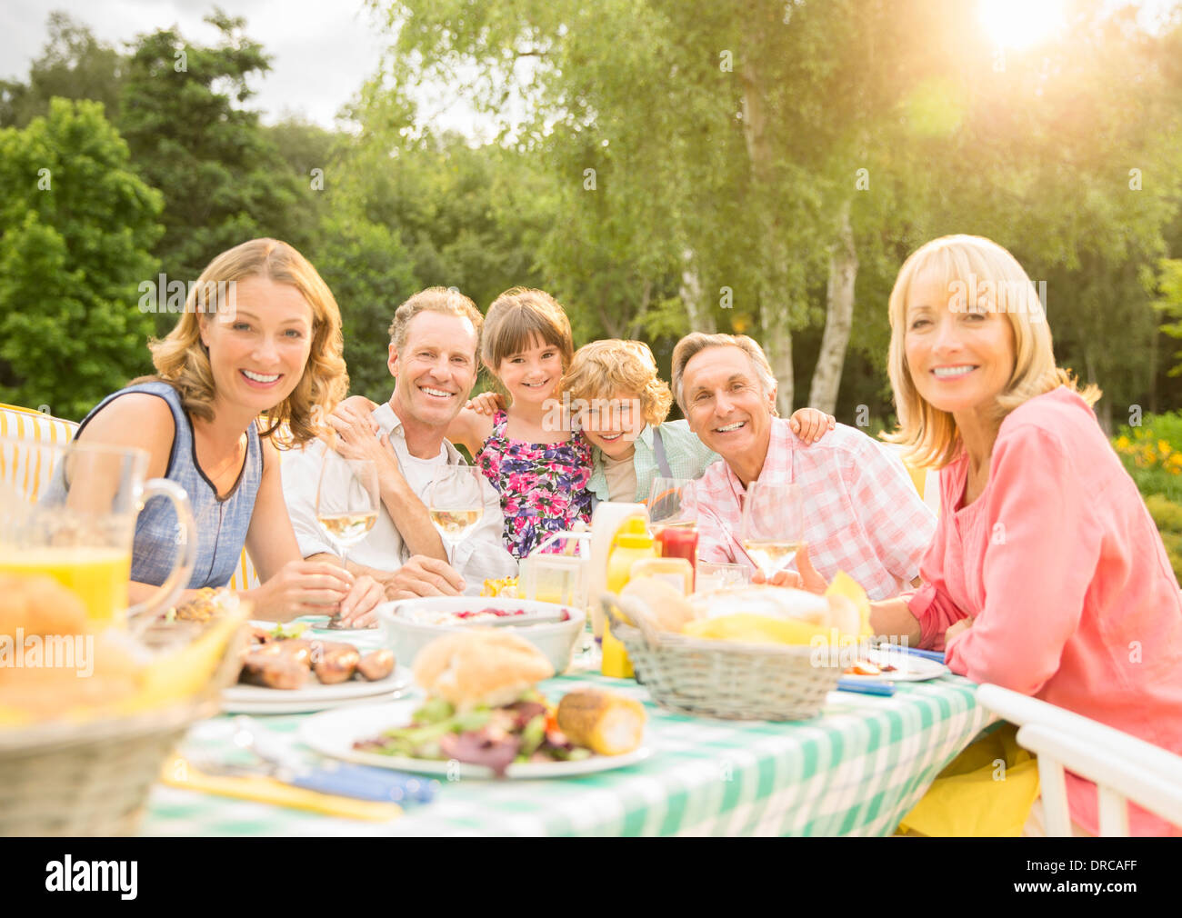 Multi-generation family enjoying lunch at table in backyard Stock Photo