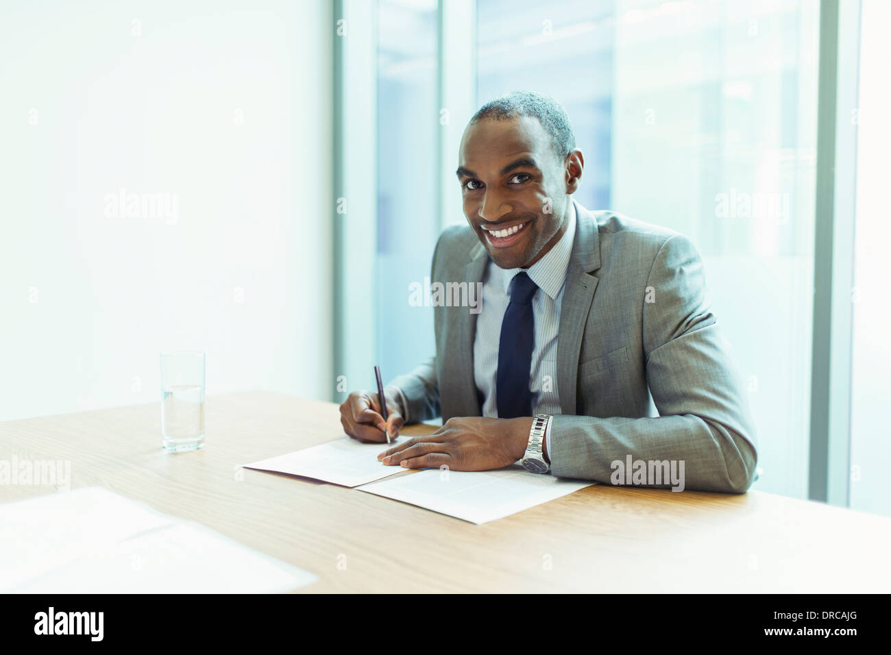 Businessman smiling at conference table Stock Photo
