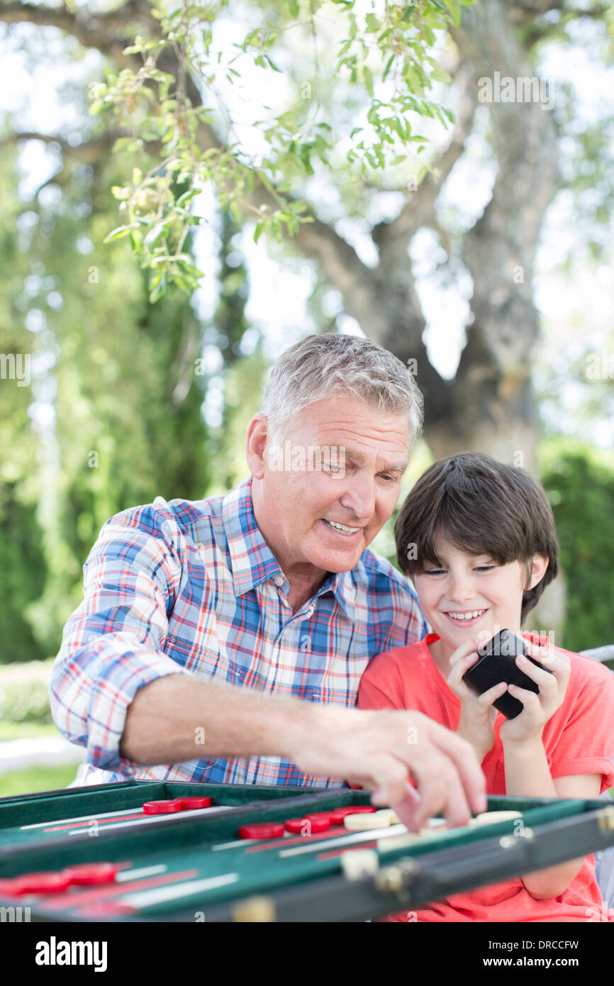 Grandfather and grandson playing backgammon Stock Photo