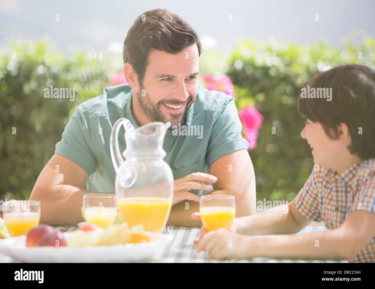 Father and son enjoying breakfast outdoors Stock Photo