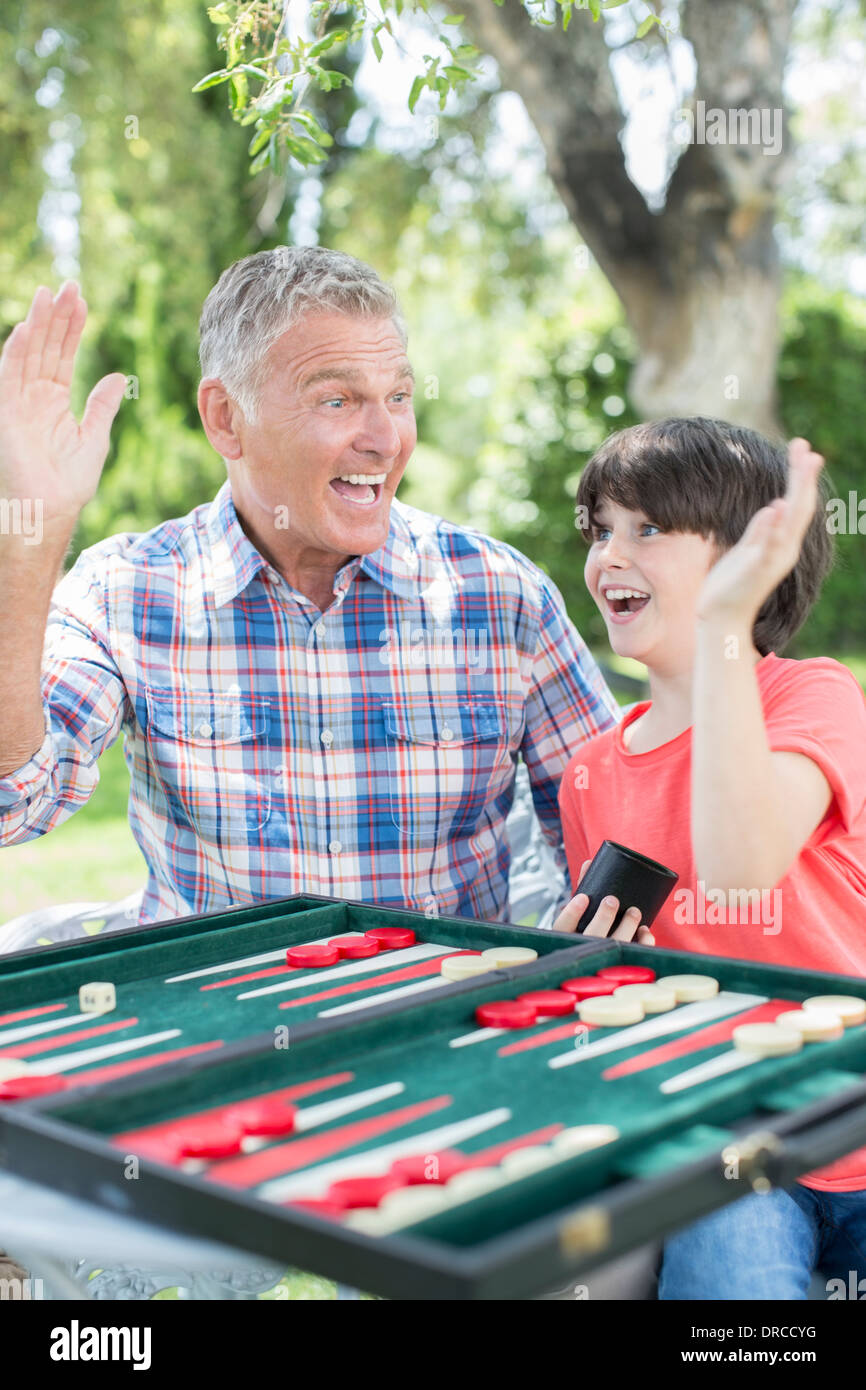 Grandfather and grandson playing backgammon Stock Photo