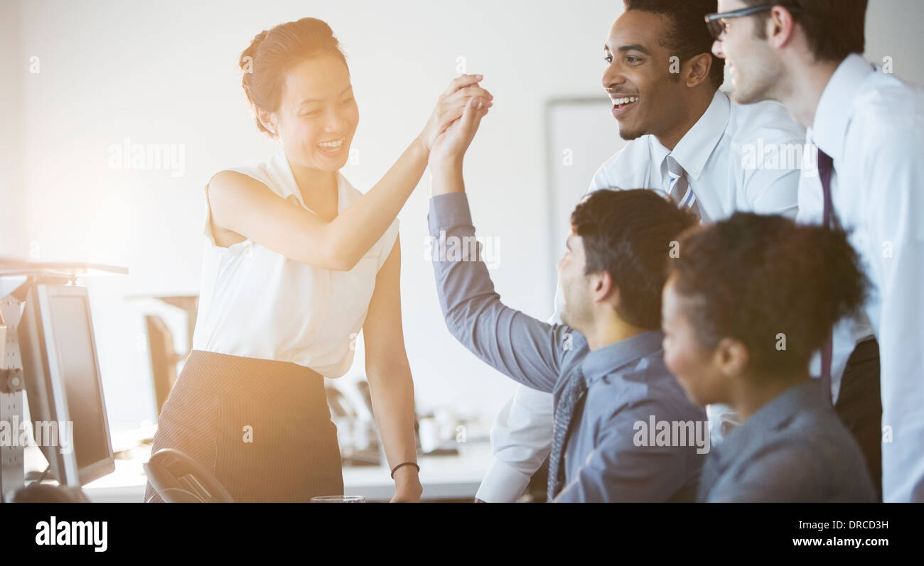 Business people cheering in office Stock Photo