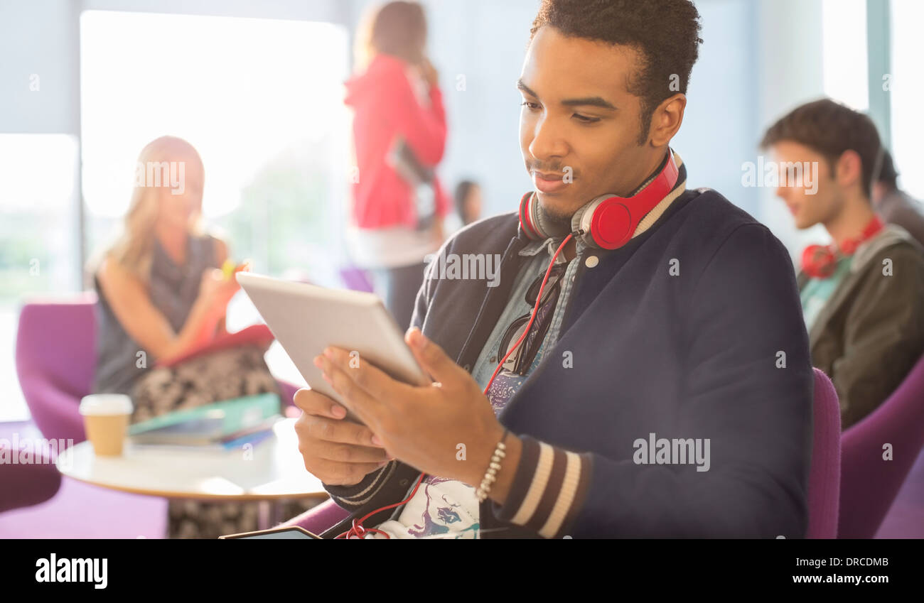 University student using digital tablet in lounge Stock Photo