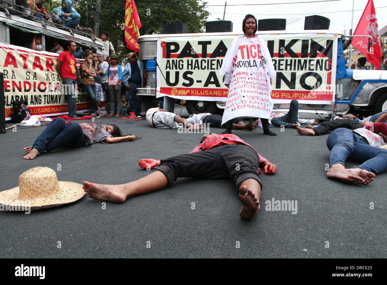 Manila, Philippines. 22nd Jan, 2014. Protesters reenact the killing of thirteen farmers at the Mendiola bridge in Manila 27 years ago. -- Militant groups trooped to Mendiola Bridge to commemorate the 13 farmers who lost their lives after government troops opened fire at a protest rally 27 years ago. Credit:  J Gerard Seguia/NurPhoto/ZUMAPRESS.com/Alamy Live News Stock Photo