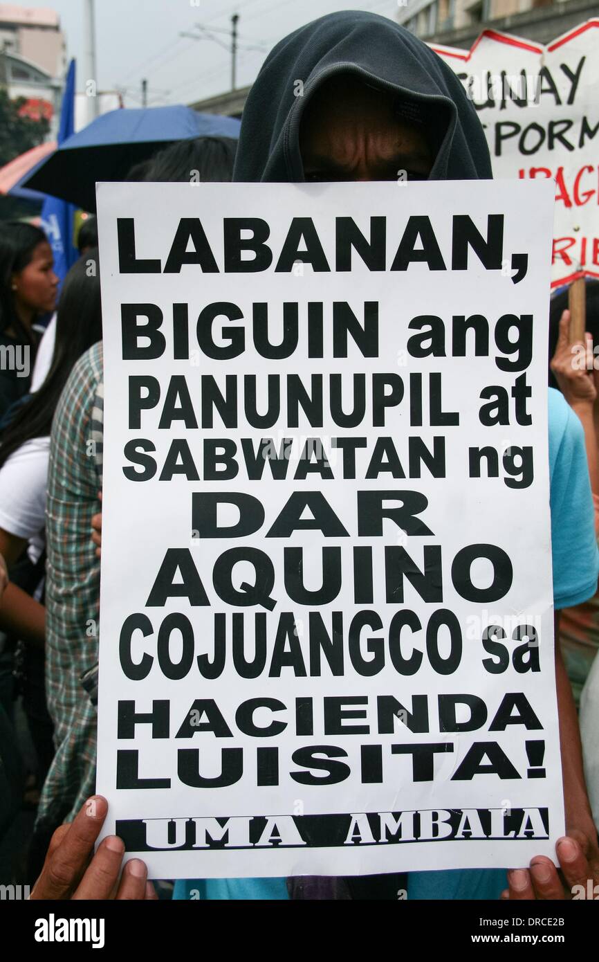 Manila, Philippines. 22nd Jan, 2014. A protester holding a poster against the alleged conspiracy of the family of President Aquino and the Department of Agrarian Reform in regards to the land distribution of Aquino owned Hacienda Luisita. -- Militant groups trooped to Mendiola Bridge to commemorate the 13 farmers who lost their lives after government troops opened fire at a protest rally 27 years ago. Credit:  J Gerard Seguia/NurPhoto/ZUMAPRESS.com/Alamy Live News Stock Photo