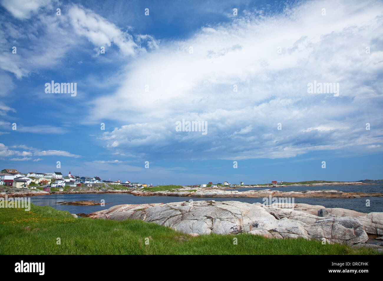 Blue sky and clouds over craggy harbor Stock Photo