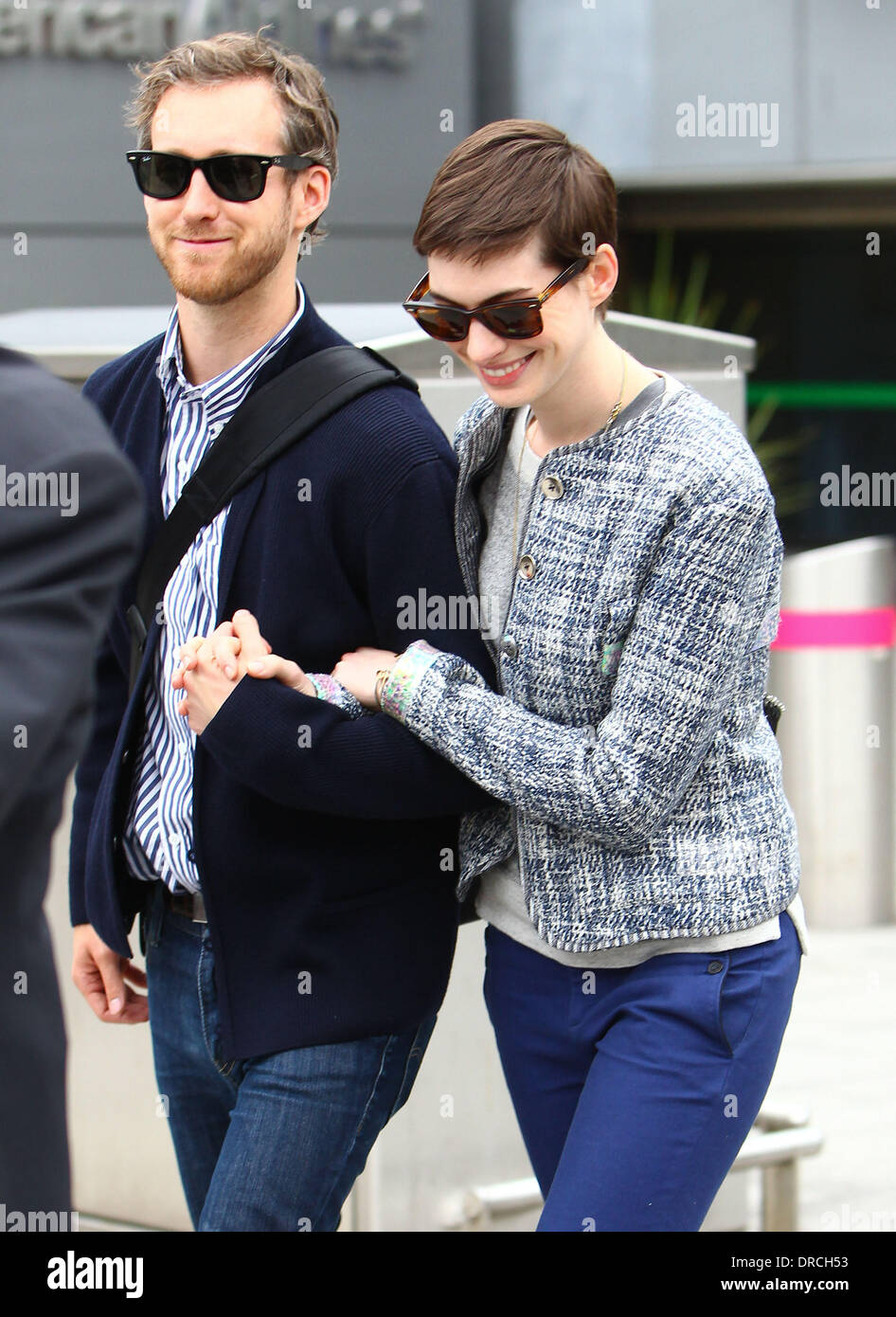 Anne Hathaway and Adam Shulman arriving at Heathrow Airport. Anne is in