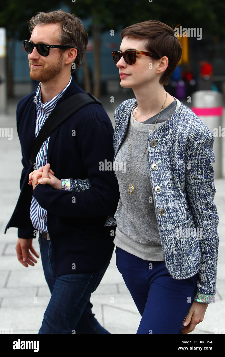 Anne Hathaway and Adam Shulman arriving at Heathrow Airport. Anne is in