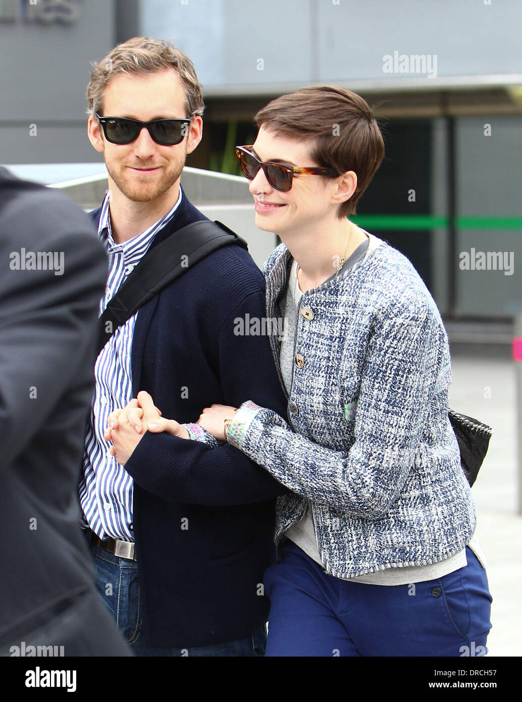 Anne Hathaway and Adam Shulman arriving at Heathrow Airport. Anne is in