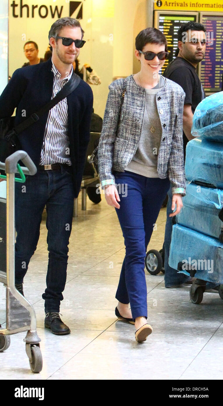 Anne Hathaway and Adam Shulman arriving at Heathrow Airport. Anne is in