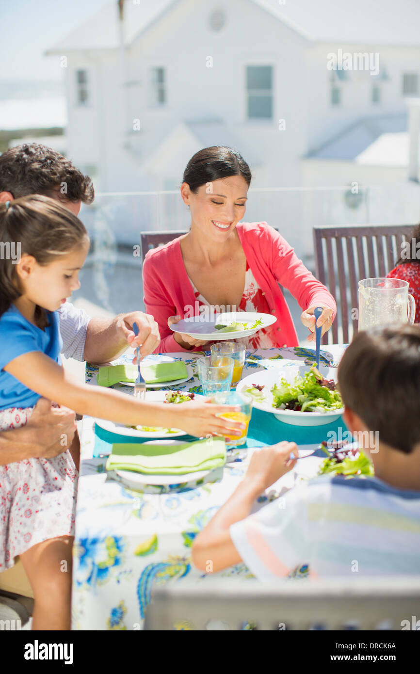 Family eating lunch at table on sunny patio Stock Photo Alamy