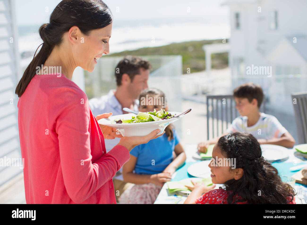 Family eating lunch at table on sunny patio Stock Photo Alamy