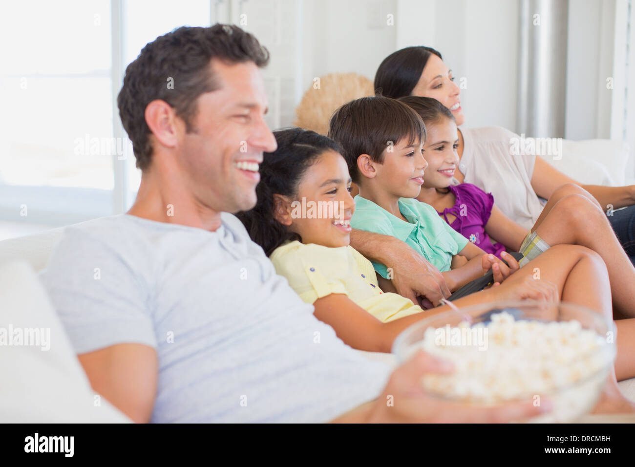 Family watching TV on sofa Stock Photo