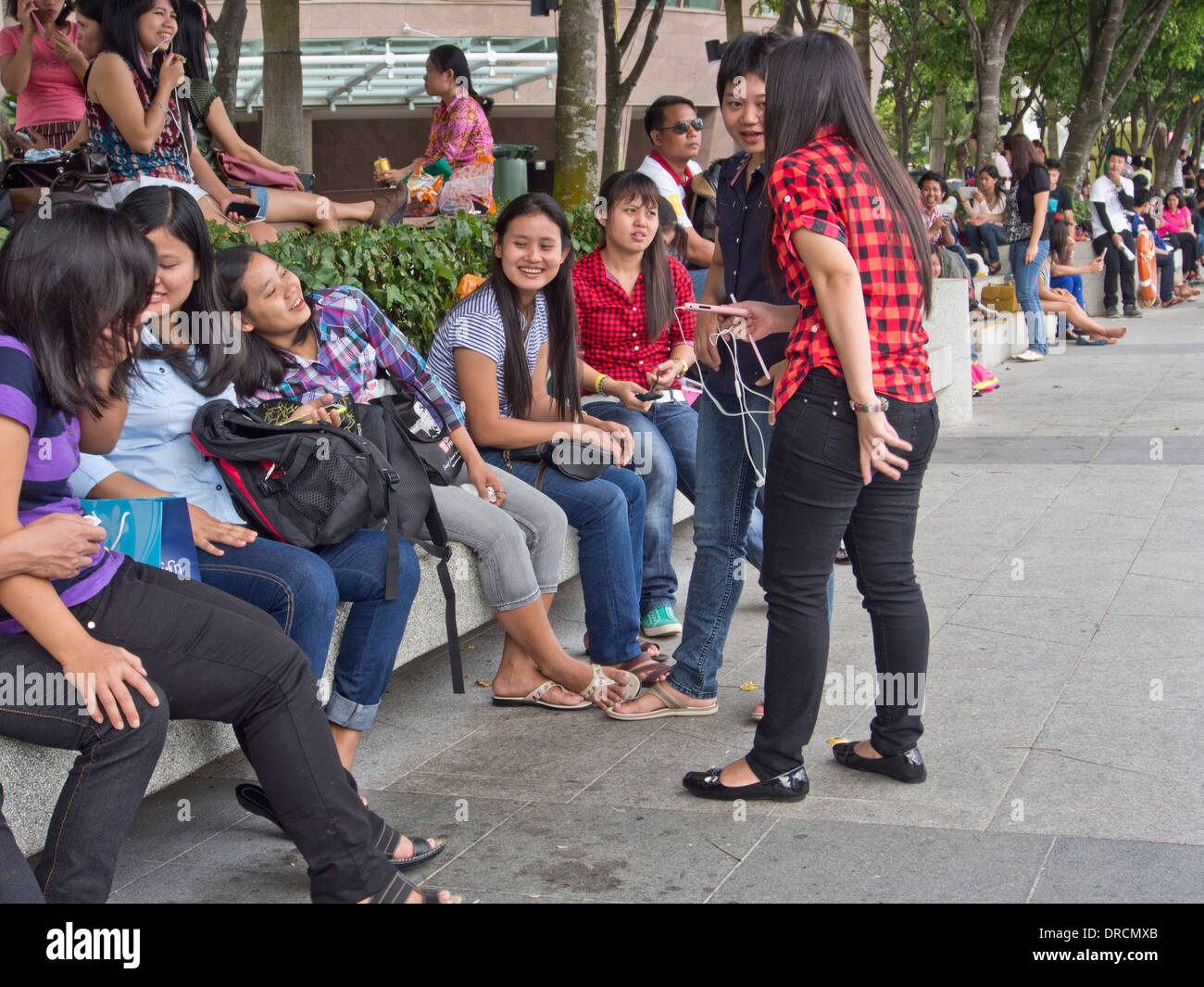 Migrant domestic workers enjoy a day off by the Bay side in Singapore Stock Photo