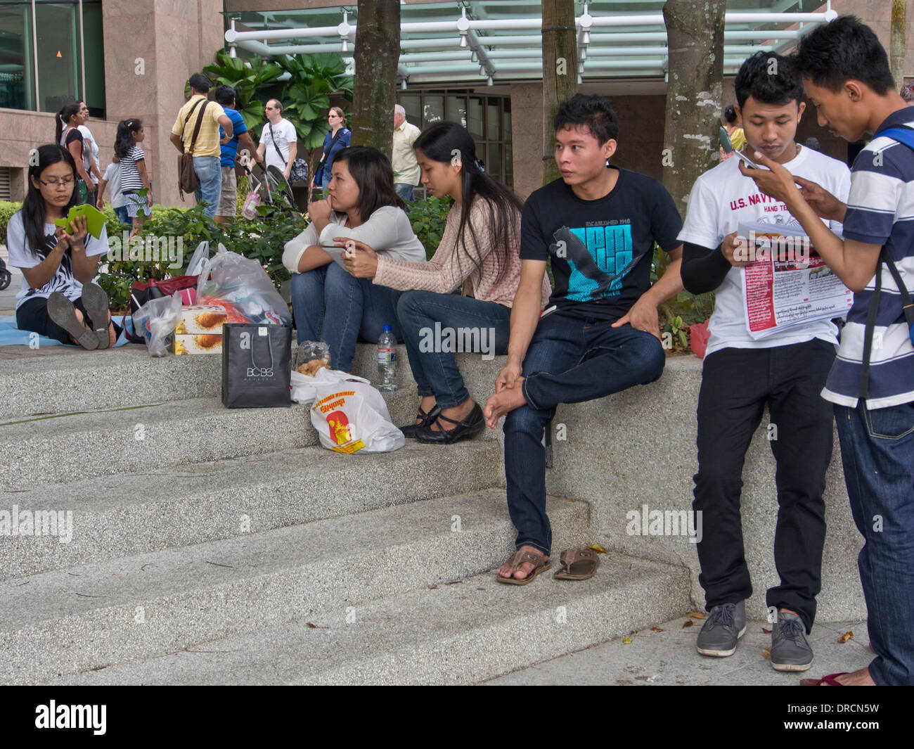 Migrant domestic workers enjoy a day off by the Bay side in Singapore Stock Photo