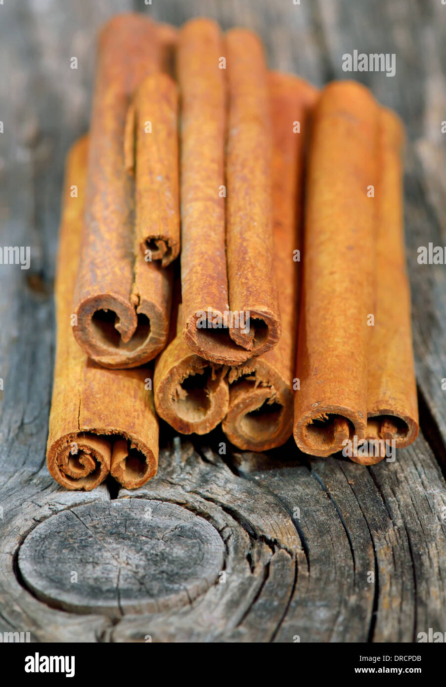 Cinnamon sticks in bucket on wooden background Stock Photo