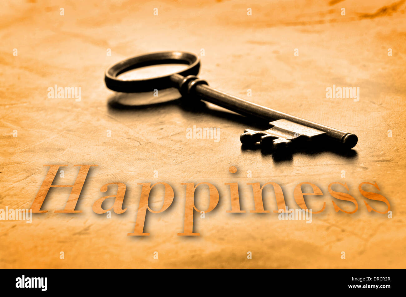 Key to Happiness on an old worn wooden desk top Stock Photo