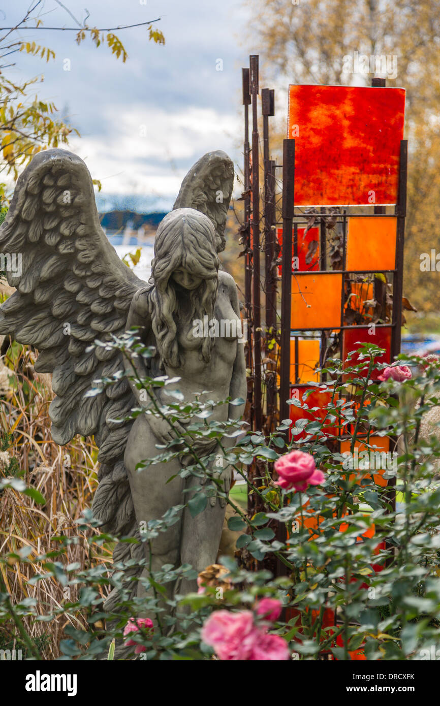 Angel statue with wings in the colorful garden Stock Photo