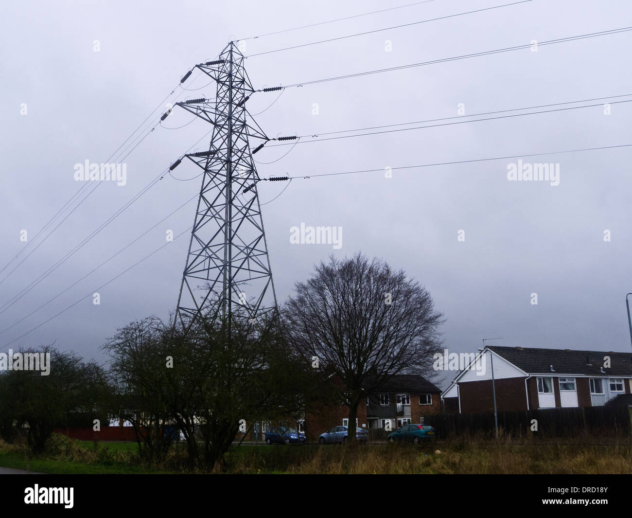 An electricity pylon in close proximity to people's homes. Stock Photo