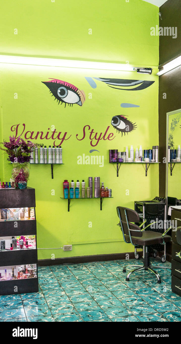 striking moderne beauty shop interior with alluring pair of giant eyes painted on chartreuse wall displaying product samples Stock Photo