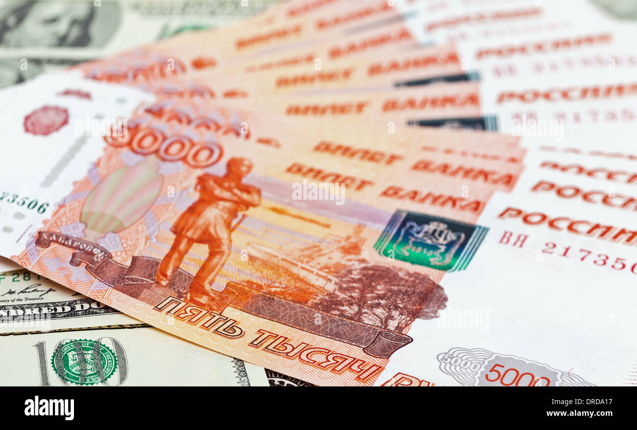 Russian roubles bills laying over dollars background Stock Photo - Alamy