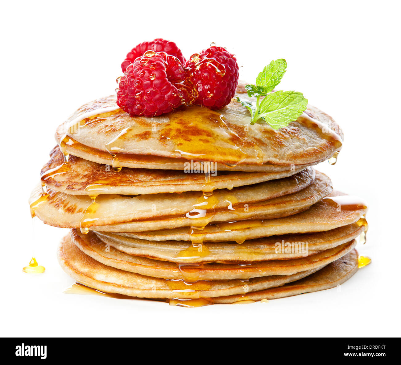 Small pancakes topped with honey, raspberries and mint on white background Stock Photo
