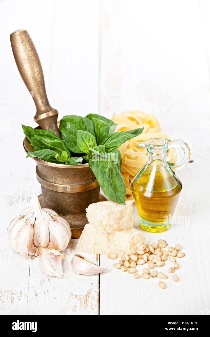 Preparing pesto in mortar on white wooden background Stock Photo Alamy